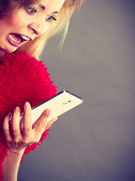 Schockierte Frau blickt auf ihr Handy — Stockfoto
