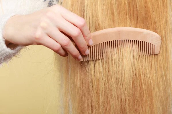 Mulher loira escovando o cabelo com pente — Fotografia de Stock