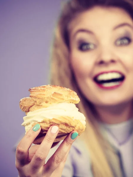 Lustige Frau hält Windbeutel-Kuchen in der Hand — Stockfoto