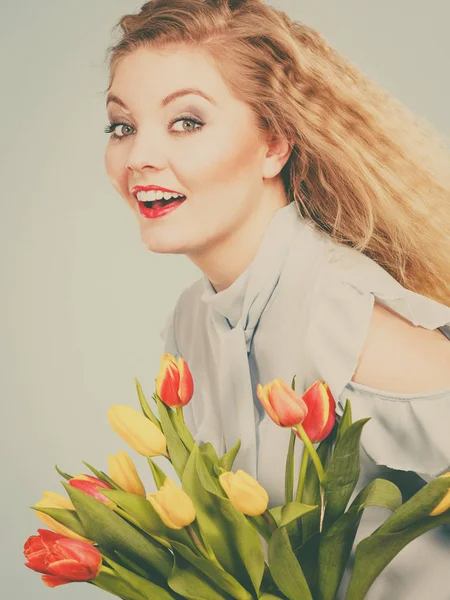 Jolie femme avec bouquet de tulipes jaunes rouges — Photo