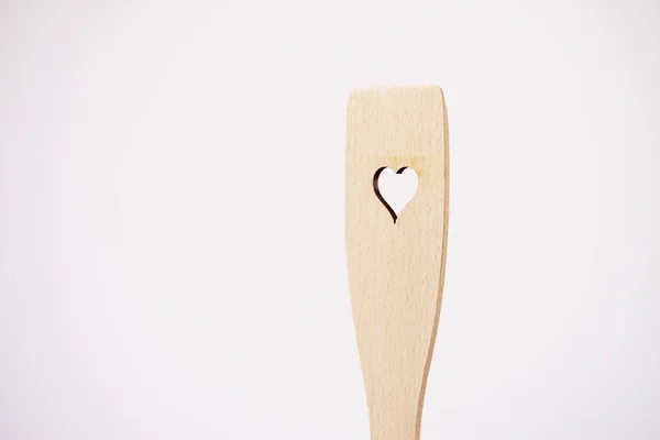 Žena držící dřevěné kuchyňské stěrky se srdcem — Stock fotografie