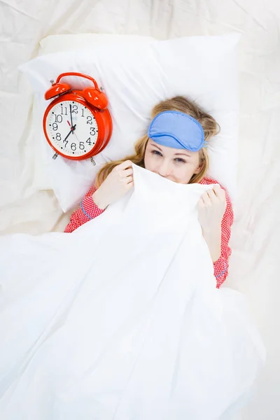 Schläfrige Frau im Schlafanzug mit Uhr — Stockfoto