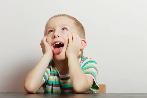 Kind macht lustige Gesichter und langweilt sich — Stockfoto