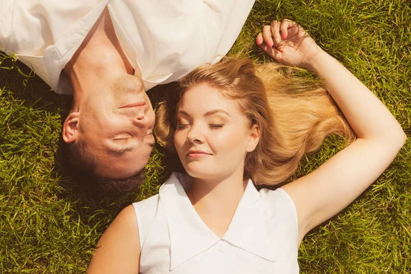 Man and woman lying on grass having date — Stock Photo, Image