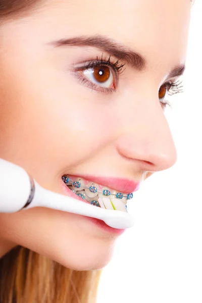 Woman smiling cleaning teeth with braces — Stock Photo, Image