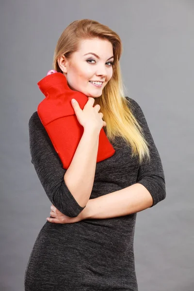 Happy woman holds hot water bottle — Stock Photo, Image