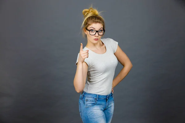 Kobieta nosząca okulary, wskazując na aparat — Zdjęcie stockowe