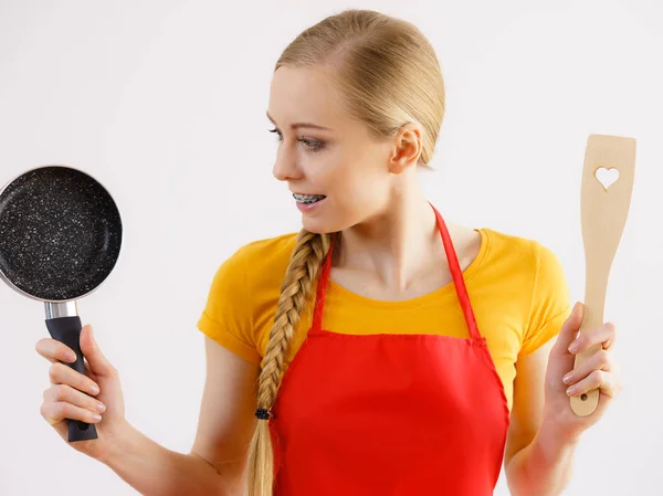 Woman holding cooking pan and spatula — Stock Photo, Image