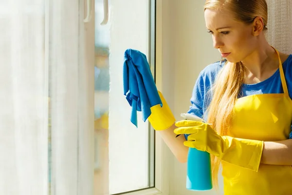 Janela de limpeza da menina em casa usando pano detergente — Fotografia de Stock