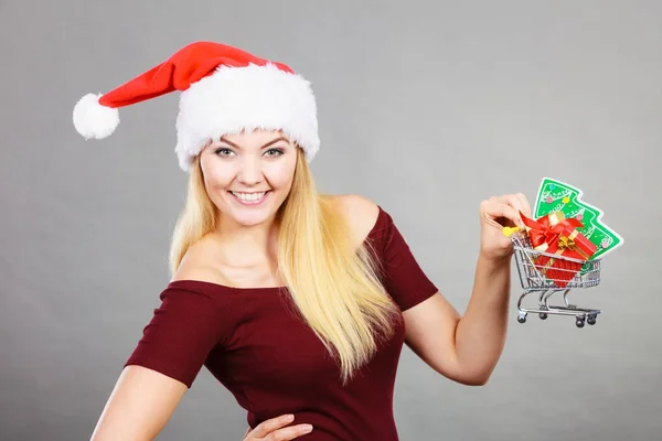 Santa woman holding shopping cart with christmas gifts — Stock Photo, Image