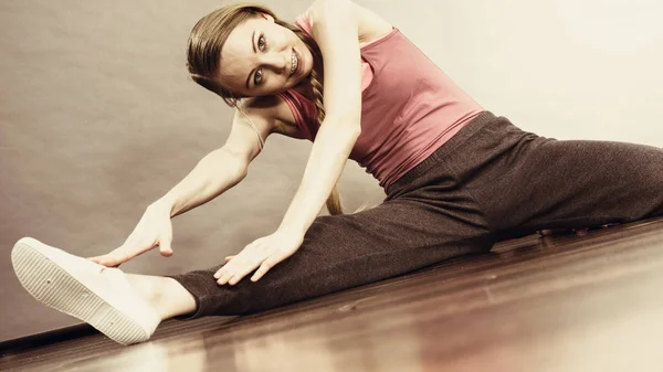 Vrouw in sportkleding benen rekken — Stockfoto