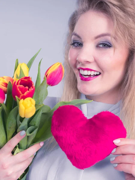 Mulher segura tulipas e coração vermelho — Fotografia de Stock