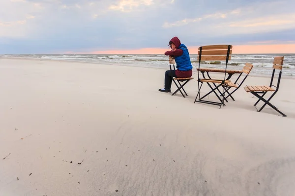 Женщина сидит на пляже расслабляясь — стоковое фото