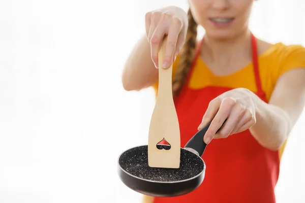 Woman hand holding cooking pan and spatula — Stock Photo, Image