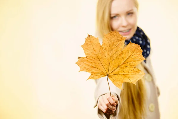 Woman holding orange autumn leaf — Stock Photo, Image