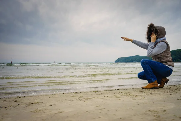 Frau spaziert am Strand, herbstlicher kalter Tag — Stockfoto