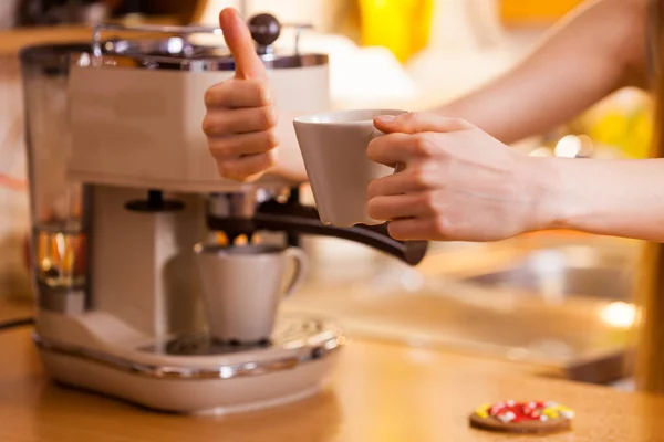 Woman in kitchen making coffee from machine — Stock Photo, Image