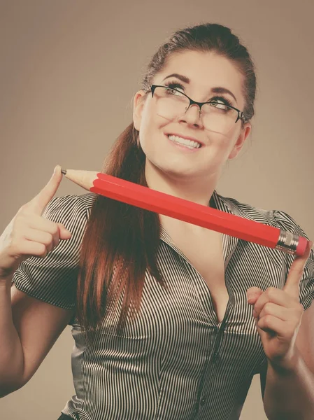 Učitel hledá elegantní žena držící velké tužka — Stock fotografie
