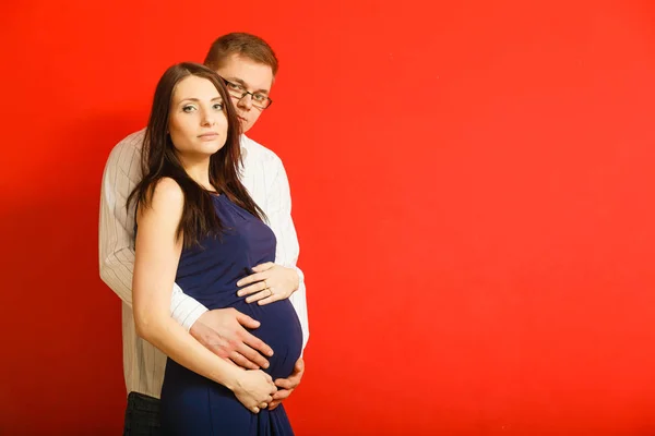 Kobieta w ciąży z wielkim brzuchem i mężczyzna pozowanie. — Zdjęcie stockowe