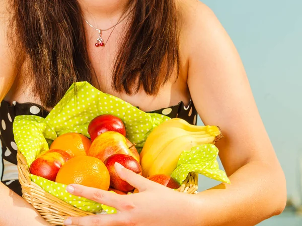 Mujer sosteniendo cesta de picnic con frutas — Foto de Stock