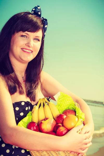Vrouw met picknickmand met vruchten — Stockfoto