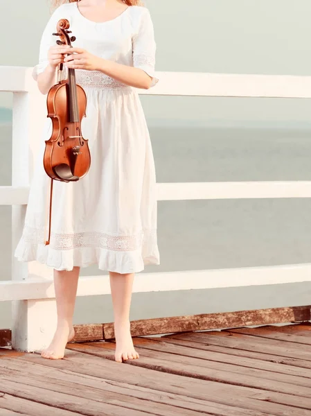 Femme sur jetée à l'extérieur tenant violon — Photo