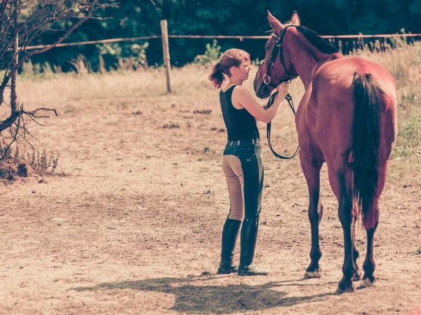 Mulher de hóquei andando com cavalo no prado — Fotografia de Stock