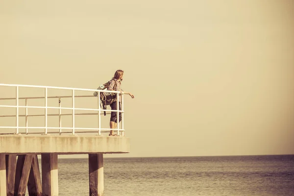 Escursionista uomo con zaino sul molo, paesaggio marino — Foto Stock