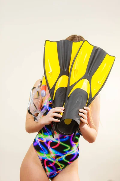 Woman covering her face with flippers having fun — Stock Photo, Image