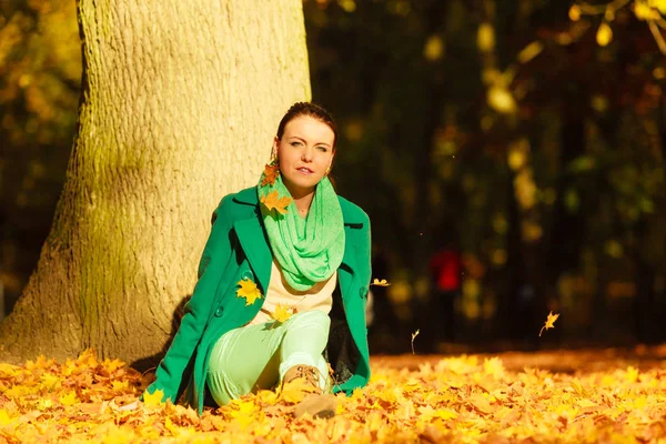 紅葉の葉の上に座っている女性 — ストック写真