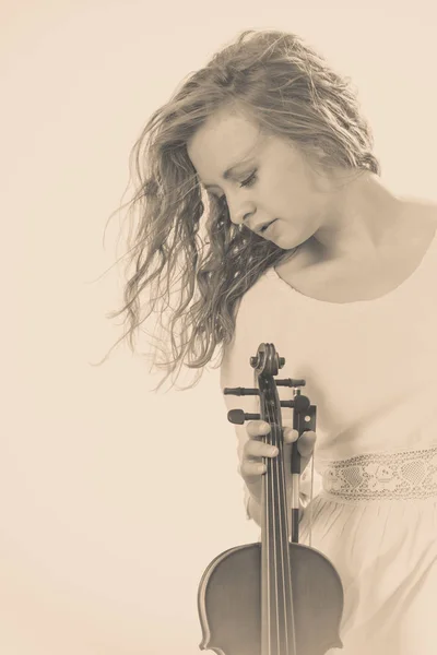 Woman on beach near sea holding violin — Stock Photo, Image