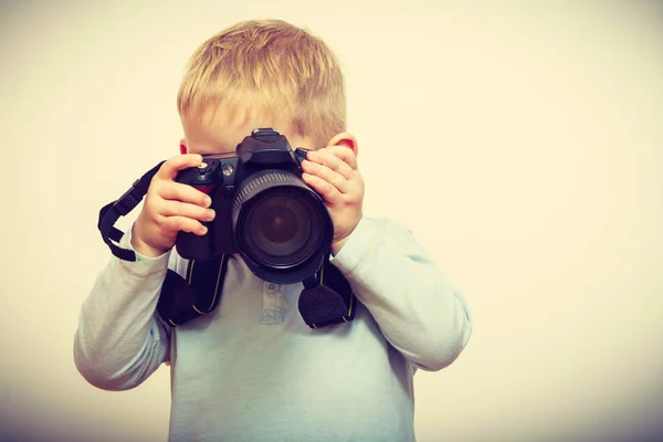 Kluk hraje s velkým profesionální digitální fotoaparát — Stock fotografie