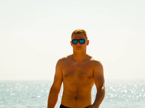 Sportieve jongeman vakantie doorbrengen op het strand — Stockfoto