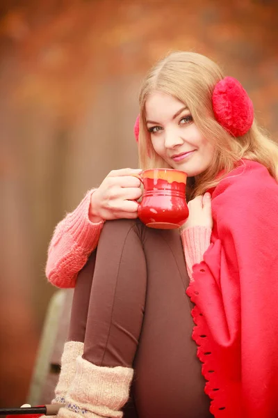 Дівчина в осінньому парку насолоджується гарячим напоєм — стокове фото