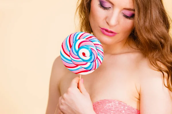 Mujer sosteniendo caramelos de piruleta de colores en la mano . — Foto de Stock