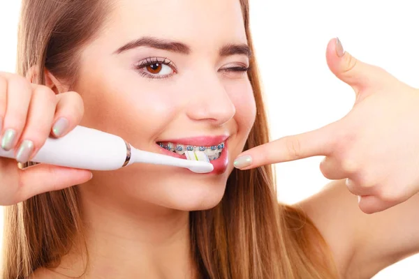 Жінка чистить зуби за допомогою брекетів — стокове фото