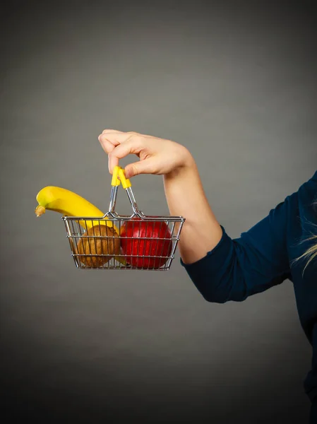 Mulher segurando cesta de compras com frutas dentro — Fotografia de Stock