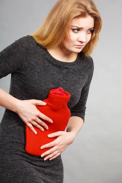 Chica teniendo dolor de estómago, sosteniendo la botella de agua caliente — Foto de Stock