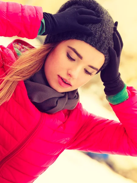 Mujer vistiendo ropa de invierno afuera sosteniendo su cabeza — Foto de Stock