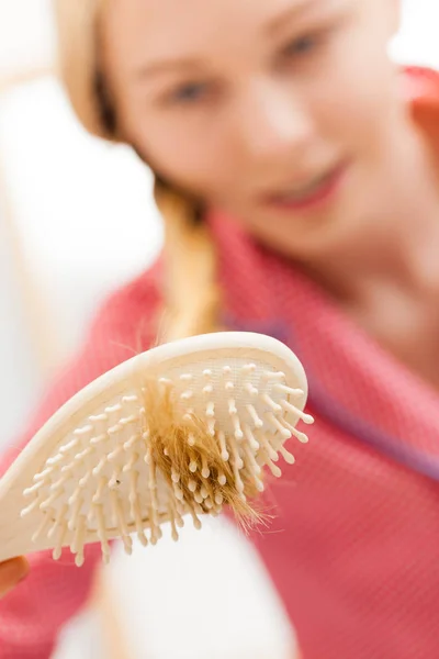 Frau bürstet ihre langen Haare im Badezimmer — Stockfoto