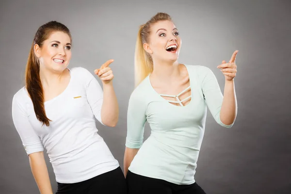 Mujeres felices señalando con un dedo . — Foto de Stock