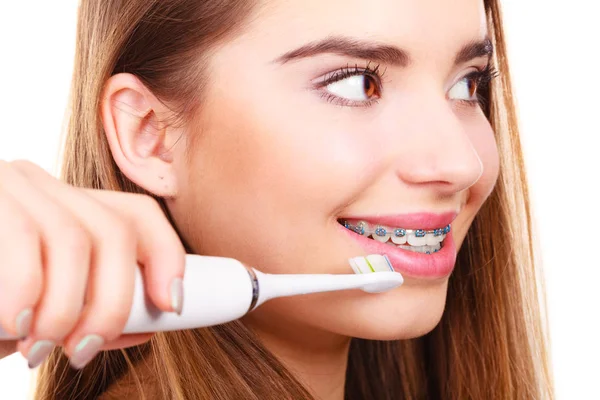 Kobieta, szczotkowanie zębów aparatem za pomocą pędzla — Zdjęcie stockowe