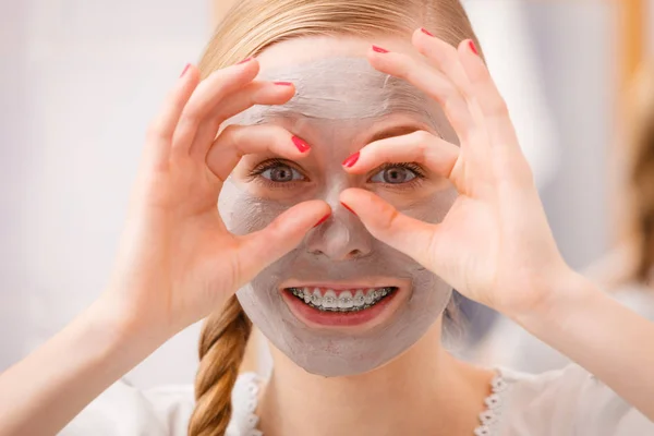 Glad ung kvinna med mud mask på ansikte — Stockfoto