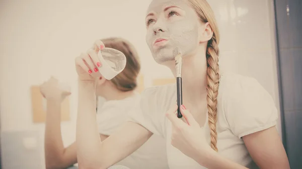 Vrouw met grijze klei modder masker op haar gezicht — Stockfoto