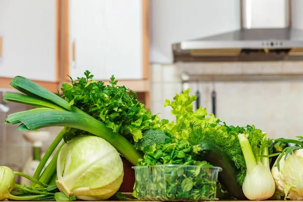 Mutfak masasının üzerinde birçok yeşil sebzeler — Stok fotoğraf
