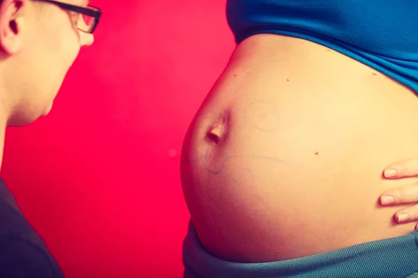 Kobieta w ciąży brzuch, ojciec rysowanie na nim — Zdjęcie stockowe
