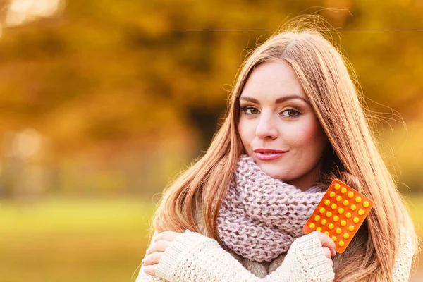 Woman in autumn park holding vitamins medicines — Stock Photo, Image