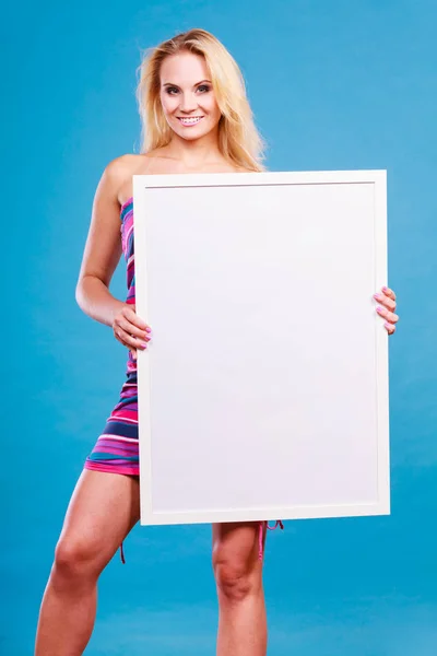 Feliz mujer rubia positiva sosteniendo pizarra blanca en blanco —  Fotos de Stock