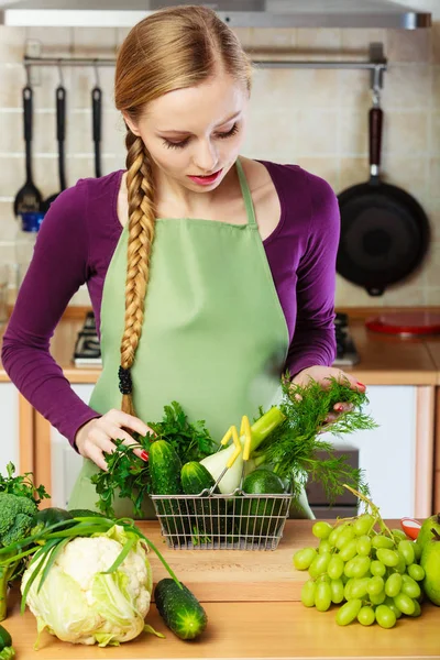 Γυναίκα στην κουζίνα έχοντας λαχανικά κρατώντας το καλάθι αγορών — Φωτογραφία Αρχείου