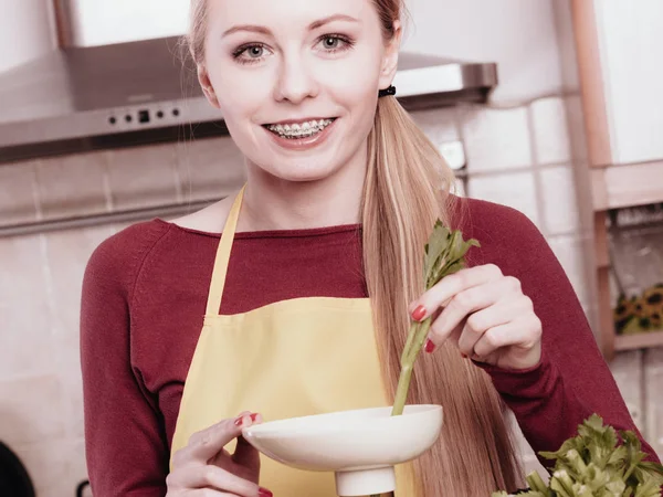Woman in kitchen making vegetable smoothie juice — Stock Photo, Image
